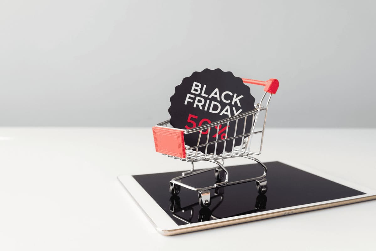 Carrinho de compras em miniatura sobre tablet pesquisando consórcio na Black Friday.