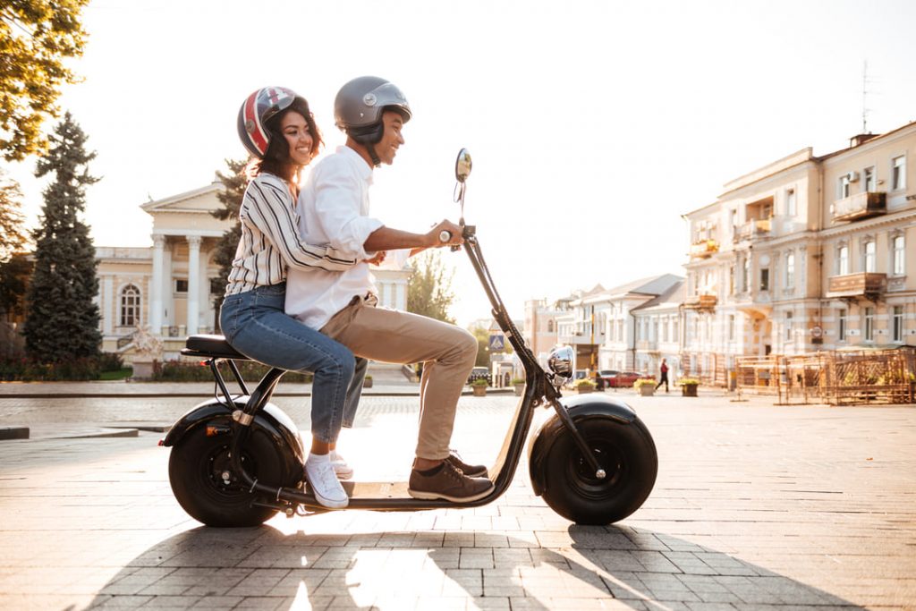 sustentabilidade ambiental: um homem e uma mulher andado em uma motocicleta elétrica. 