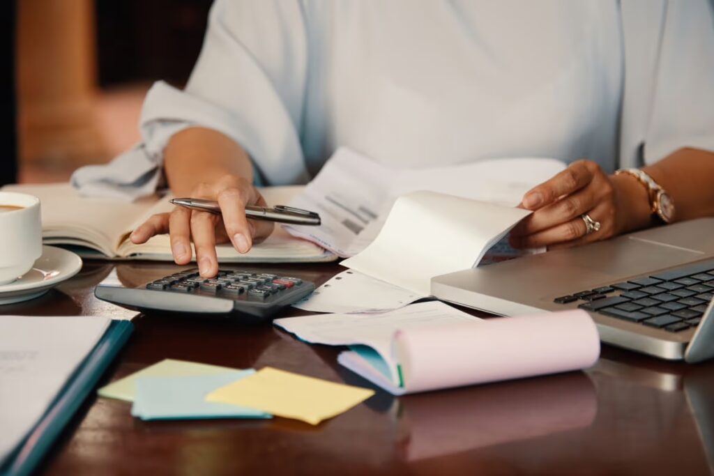 O que é cheque especial: mulher usando calculadora e mexendo com papéis