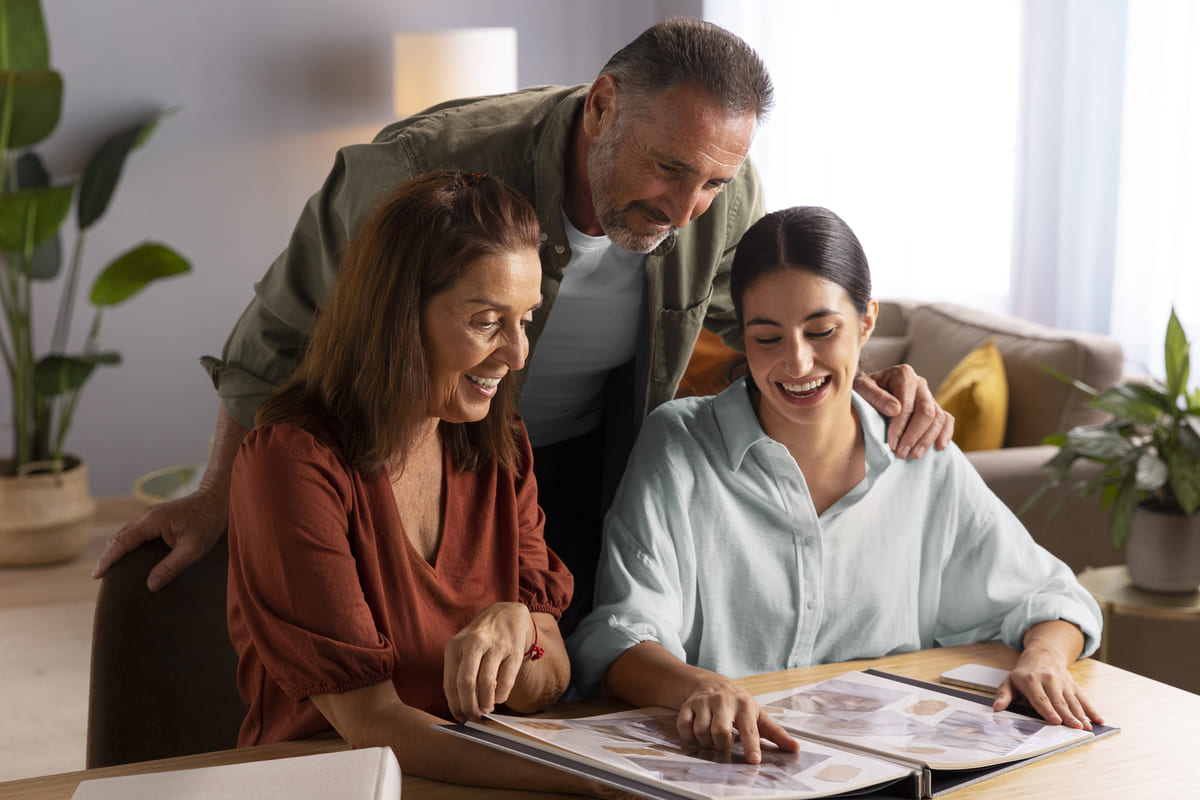 Família feliz revisando um álbum de fotos, um momento que inspira o planejamento de metas futuras e reforça a importância de um bom orçamento familiar para a realização de sonhos.