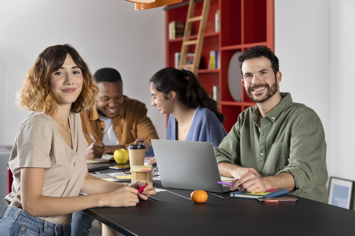 Grupo de jovens da geração Z estudando e colaborando em ambiente moderno, utilizando laptop, cadernos e materiais coloridos.