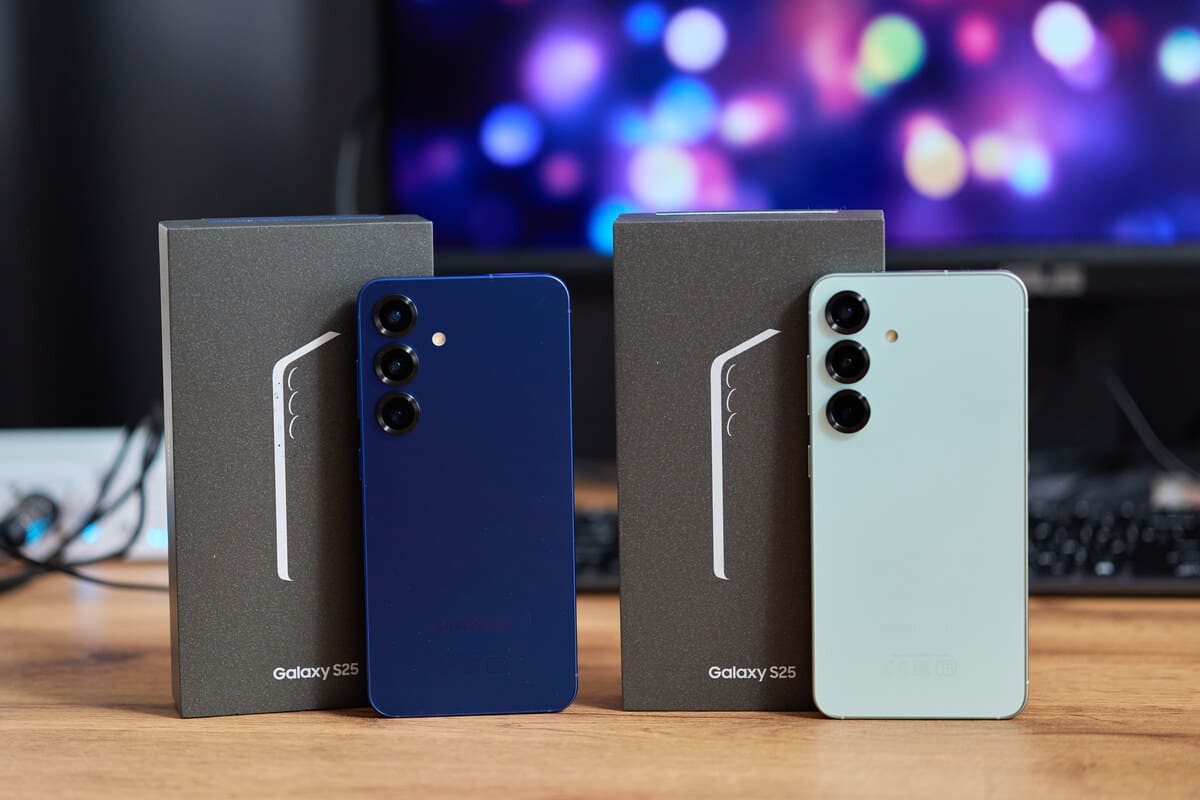 Dois novos smartphones Samsung Galaxy S23, um azul-marinho e um verde-menta, ao lado de suas caixas de varejo cinzas, exemplificando novos produtos Samsung.