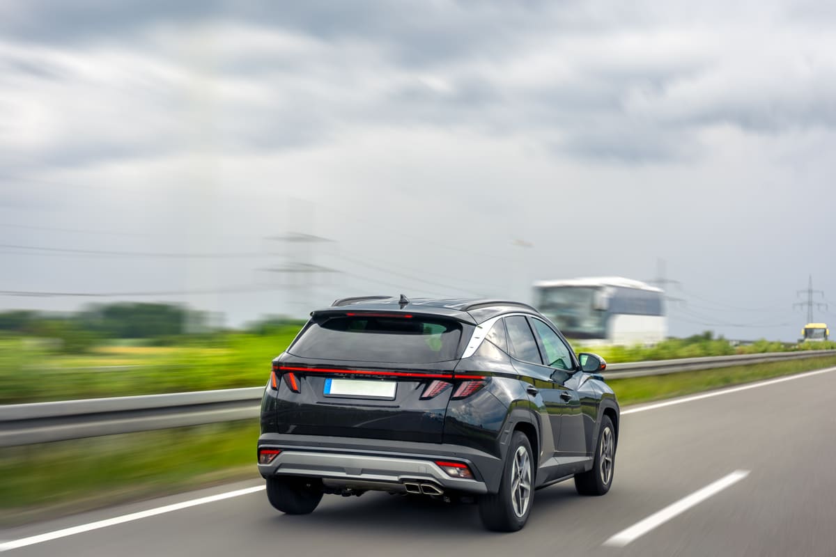 SUV preto em movimento por uma rodovia, representando o desempenho das melhores marcas de carro.