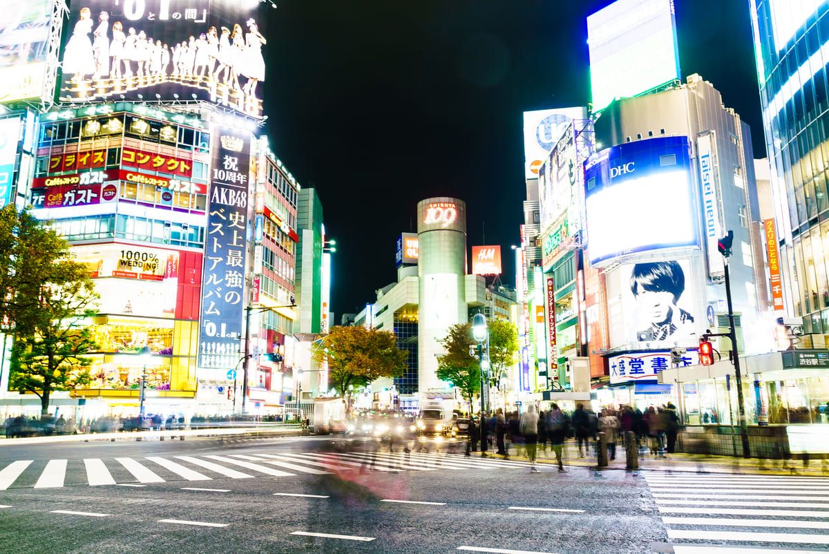 Cruzamento de Shibuya iluminado à noite com pedestres para o roteiro de o que fazer em Tóquio.