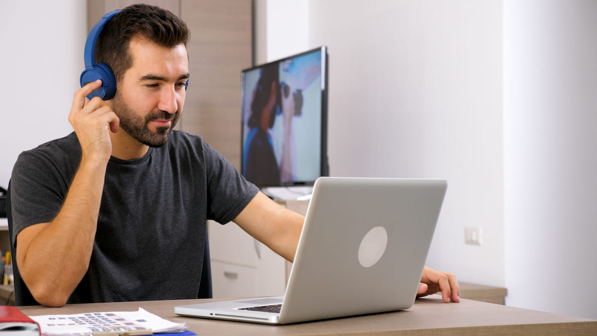 Profissional com headset no escritório diante do melhor notebook para trabalho.
